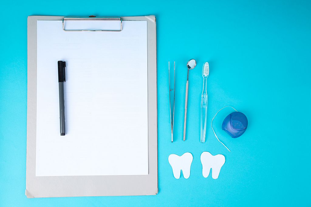 Clipboard and Dental Tools on Blue Background for Oral Health Presentation